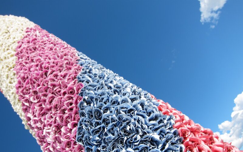 Colorful flower sculpture against blue sky