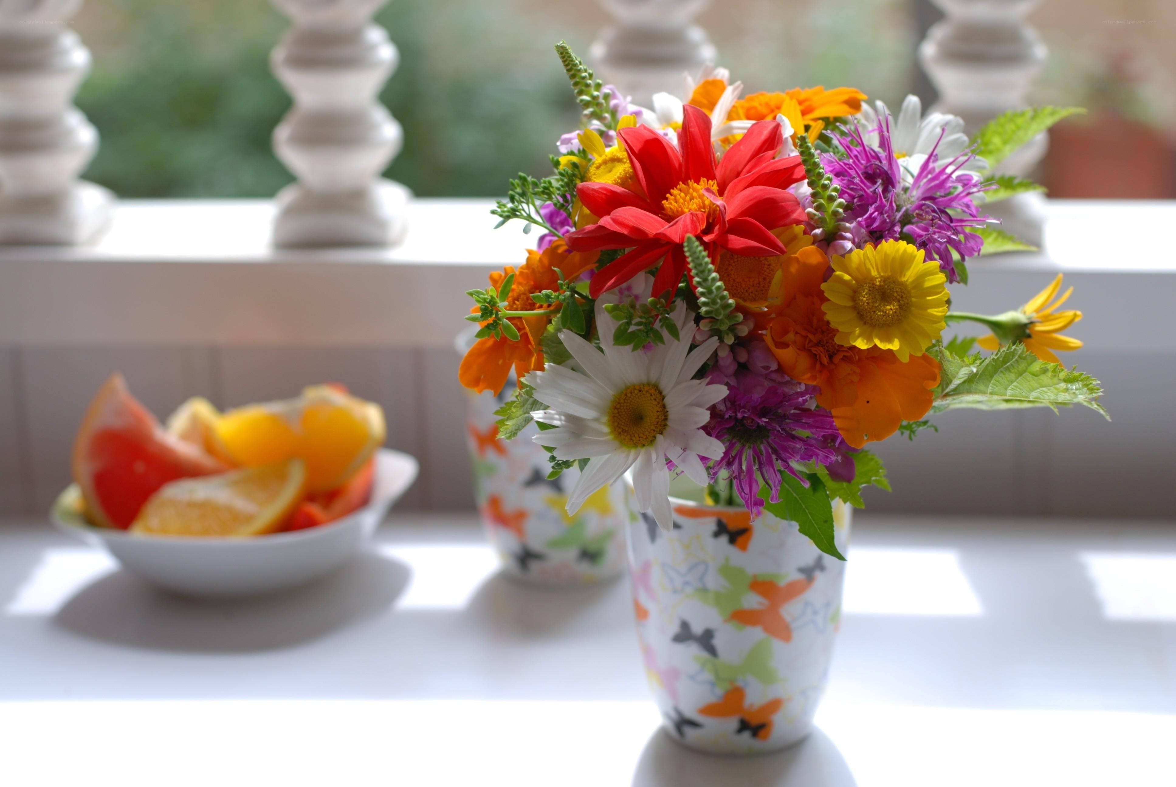 Colorful flowers and fruit bowl