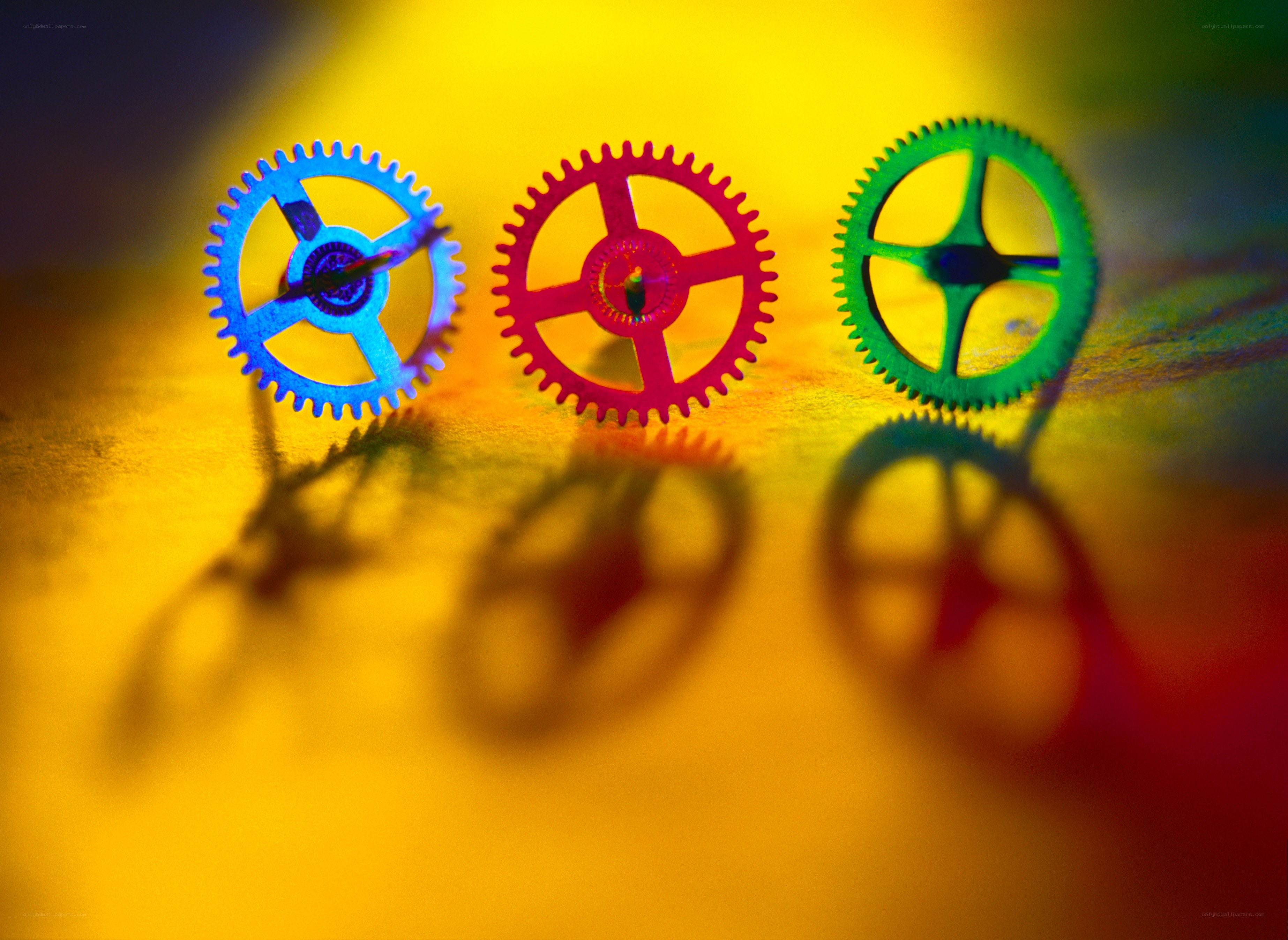 Colorful gears on yellow background