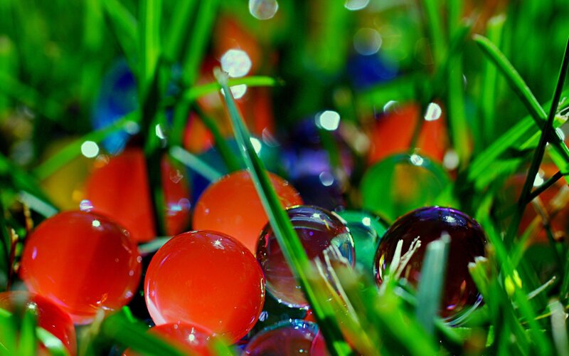 Colorful glass beads in grass