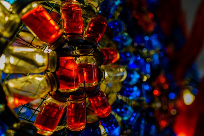 Colorful glass bottles on wire rack
