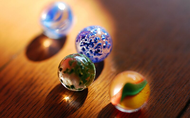 Colorful glass marbles on wood