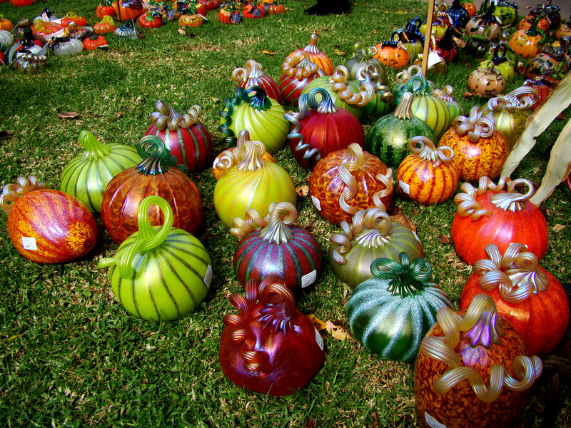 Colorful glass pumpkins on grass