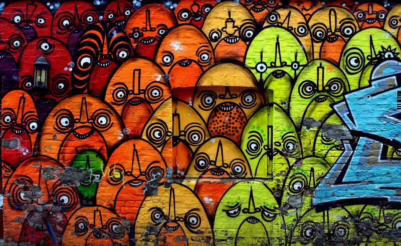 Colorful graffiti faces on brick wall