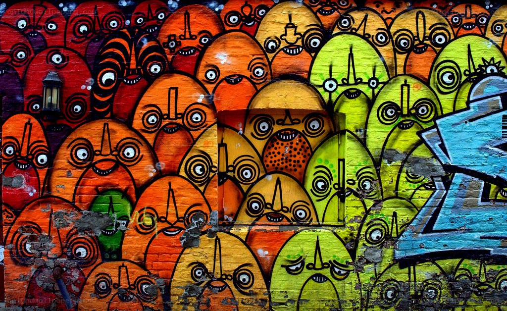 Colorful graffiti faces on brick wall