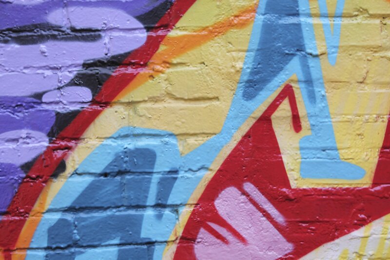 Colorful Graffiti on Brick Wall — Yellow