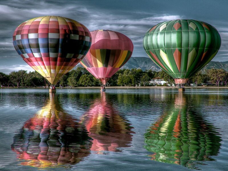 Colorful hot air balloons over a lake