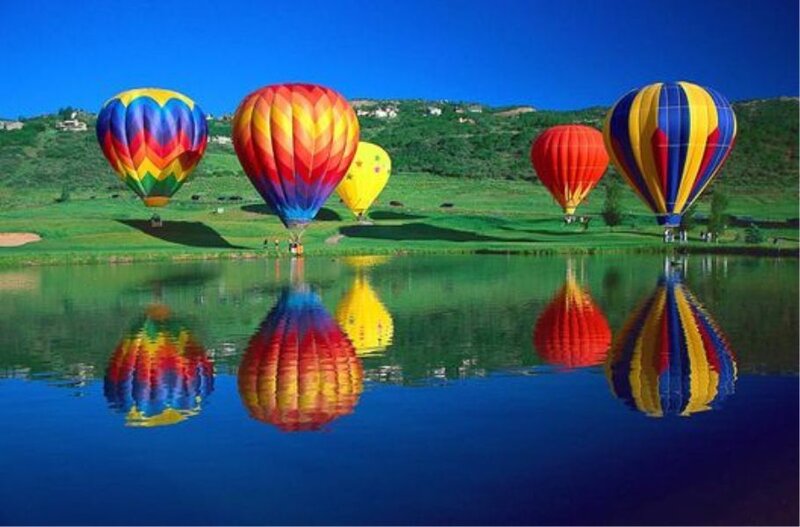 Colorful hot air balloons over lake