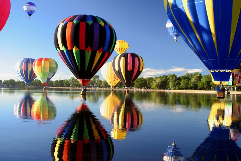 Colorful hot air balloons over lake