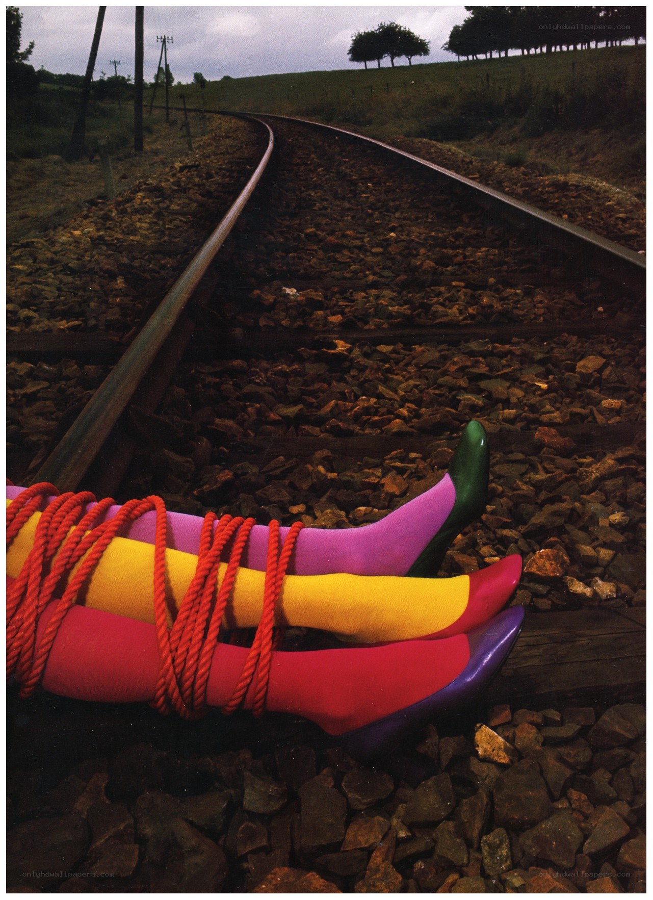 Colorful legs bound on train tracks