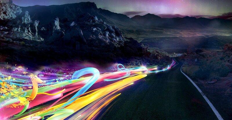 Colorful light trails on a mountain road