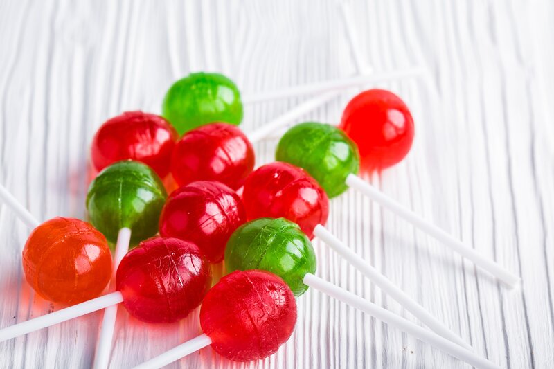 Colorful lollipops on white wood