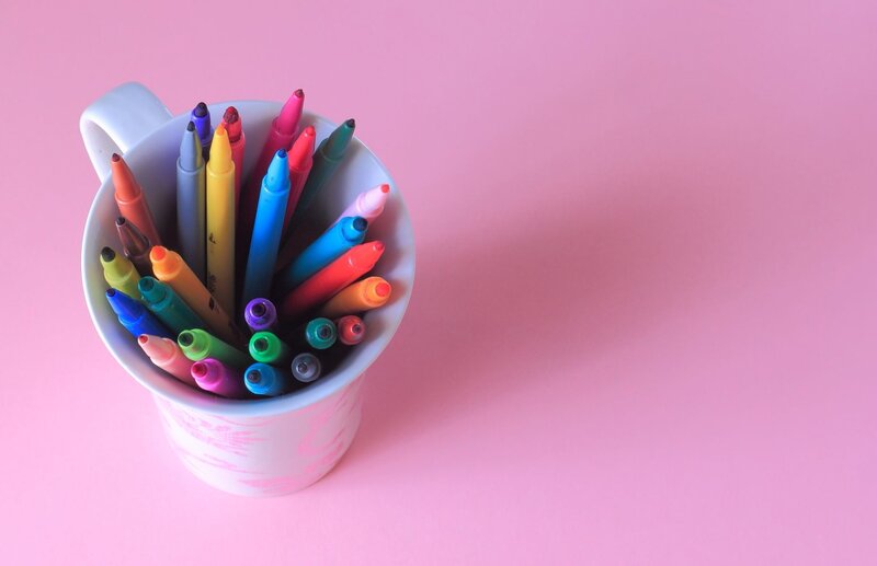 Colorful markers in a mug