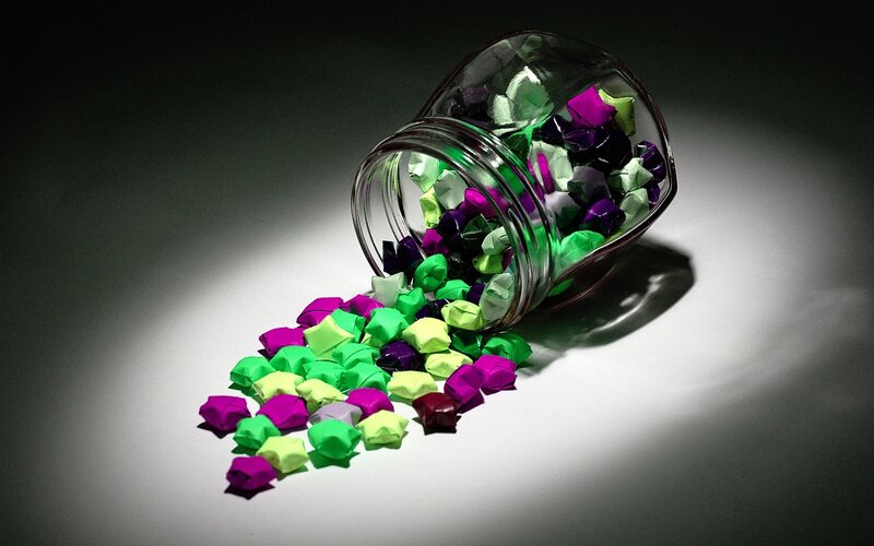 Colorful origami stars spilled from jar