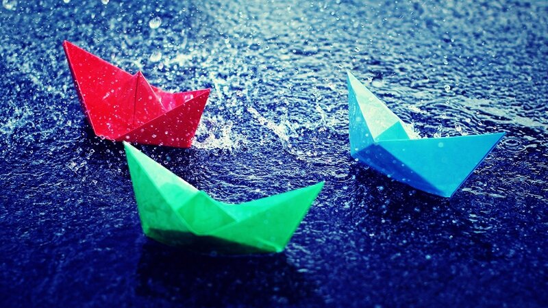 Colorful paper boats in rain