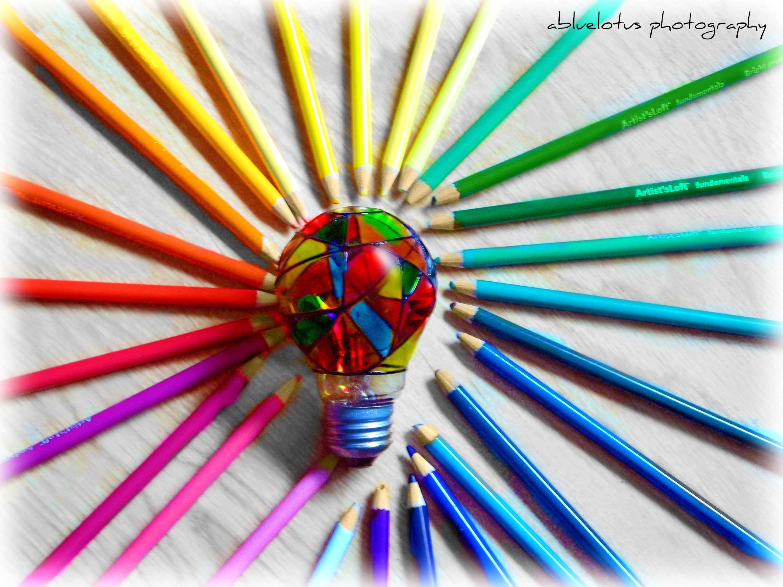 Colorful pencils around light bulb