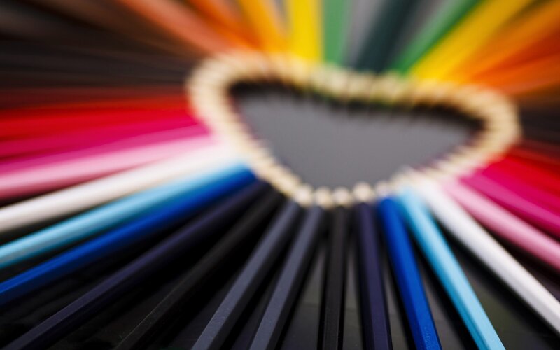 Colorful pencils arranged in heart shape