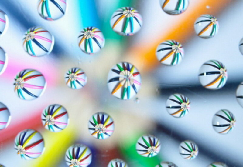 Colorful Pencils in Water Droplets
