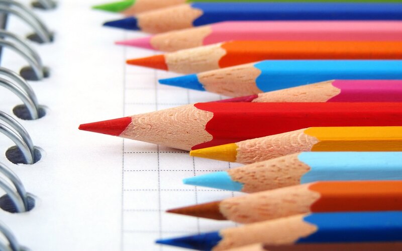 Colorful pencils on notebook paper