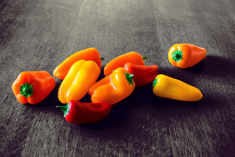 Colorful peppers on dark wood