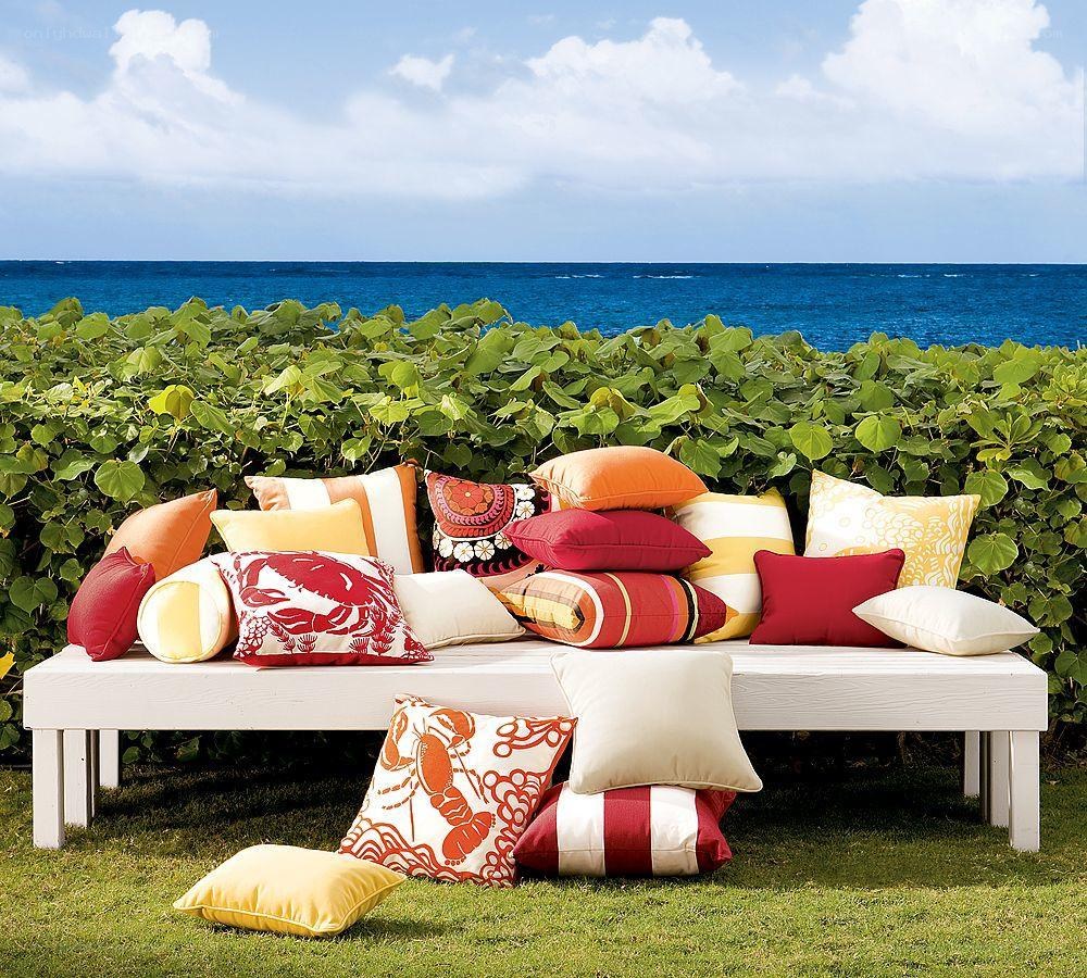 Colorful pillows on bench by ocean