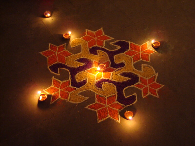 Colorful rangoli with oil lamps