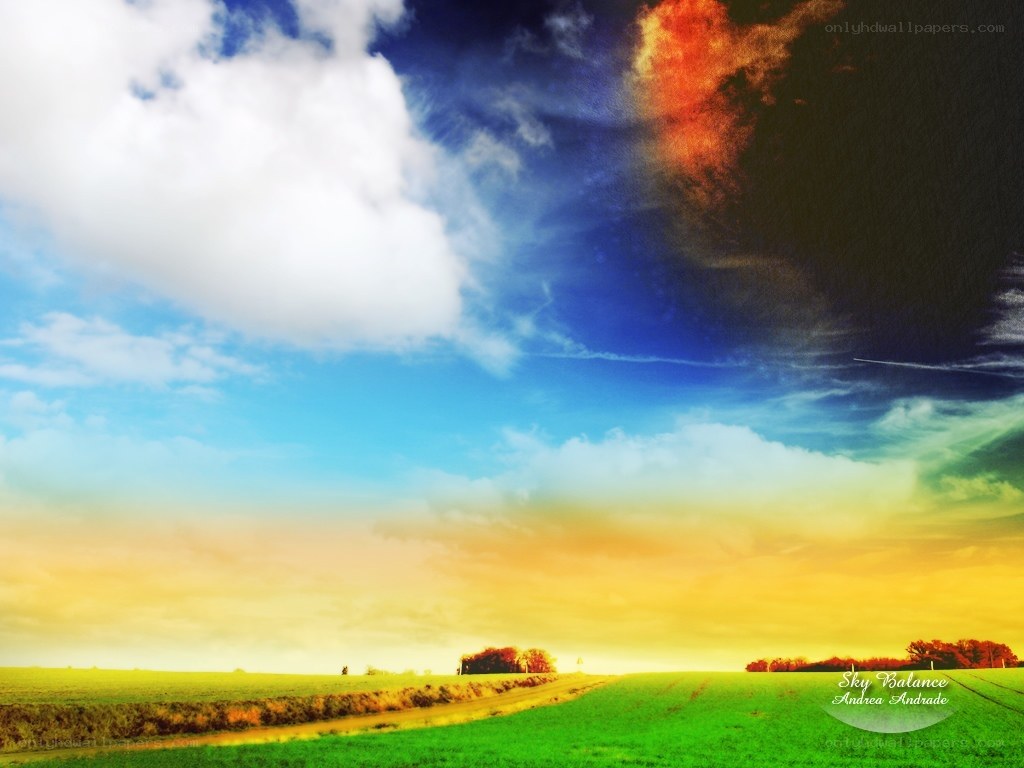 Colorful sky over green fields