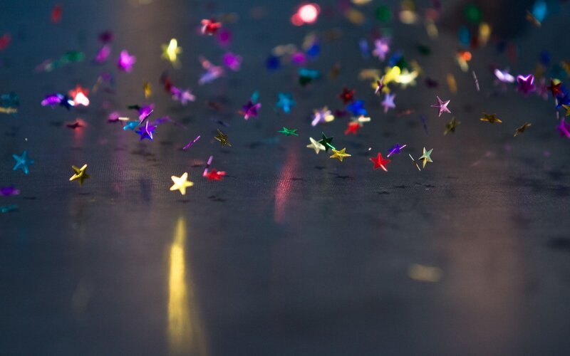 Colorful star confetti on dark surface