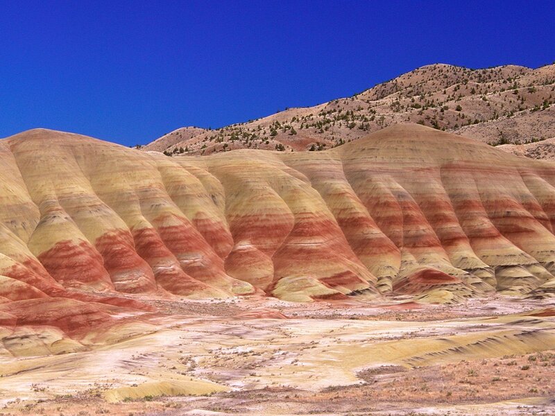 Colorful striped hills under blue sky
