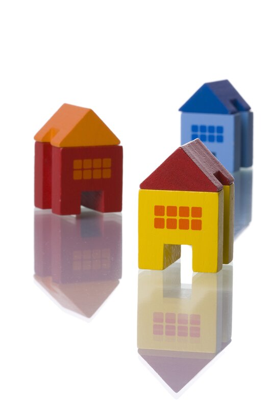Colorful toy houses on reflective surface