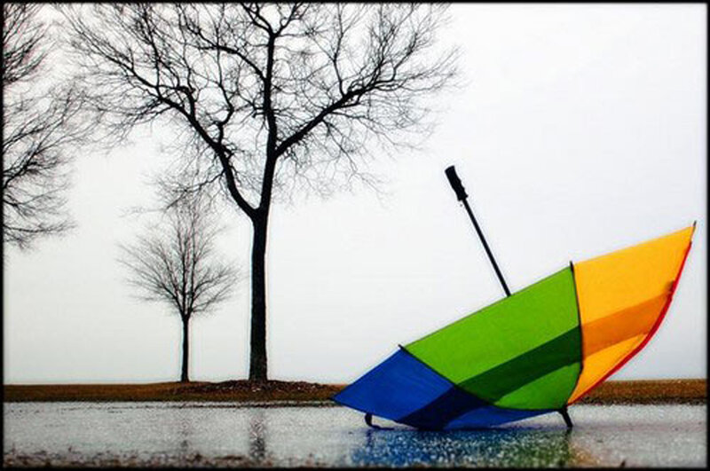 Colorful umbrella on wet ground