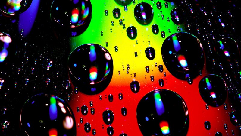 Colorful water droplets on rainbow background