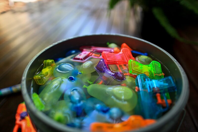 Colorful water guns in a bucket