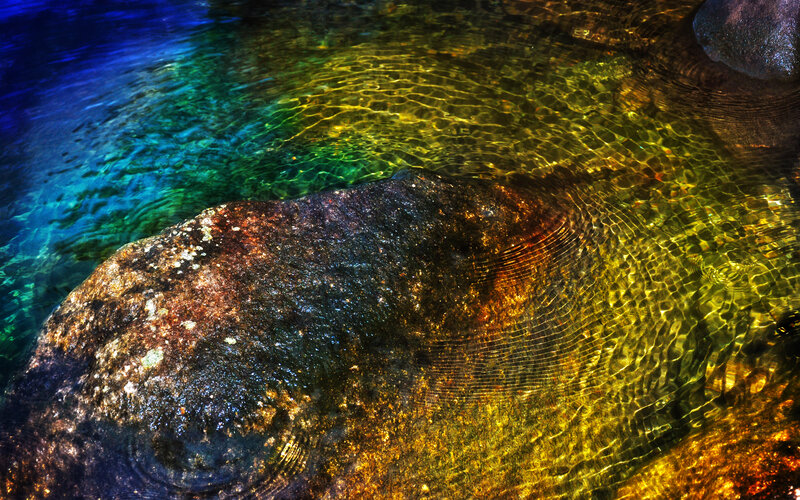 Colorful water ripples over rocks