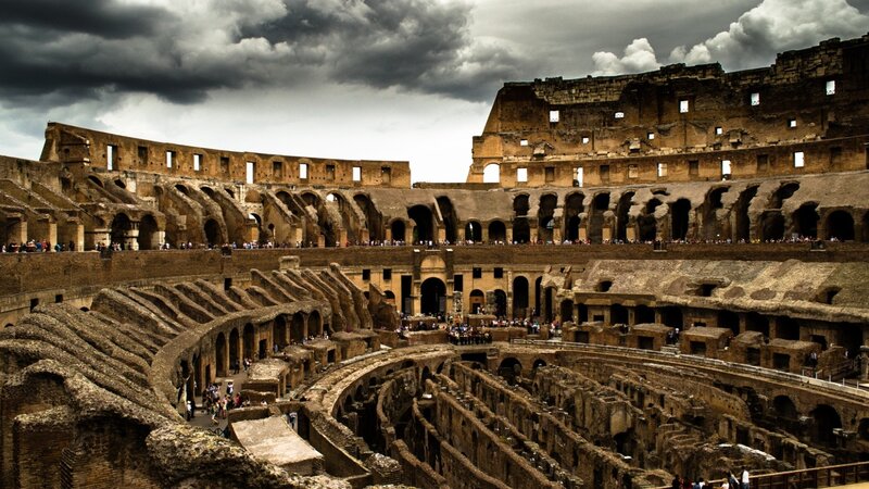 Colosseum interior under stormy sky