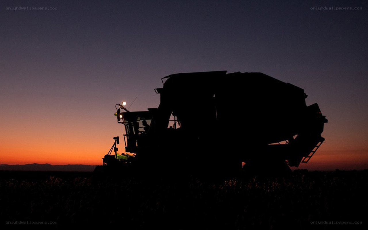 Combine harvester at sunset
