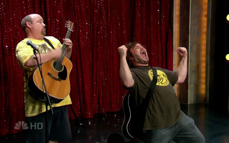Comedians on stage with guitars
