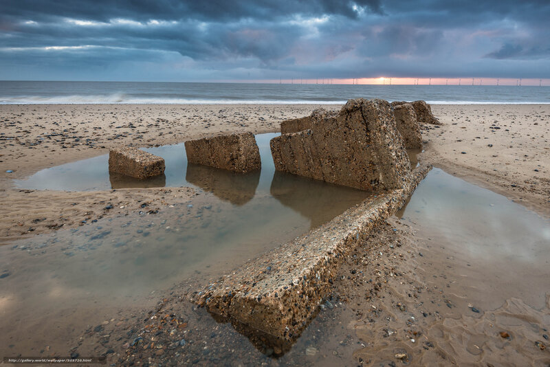 Concrete blocks on beach at sunset