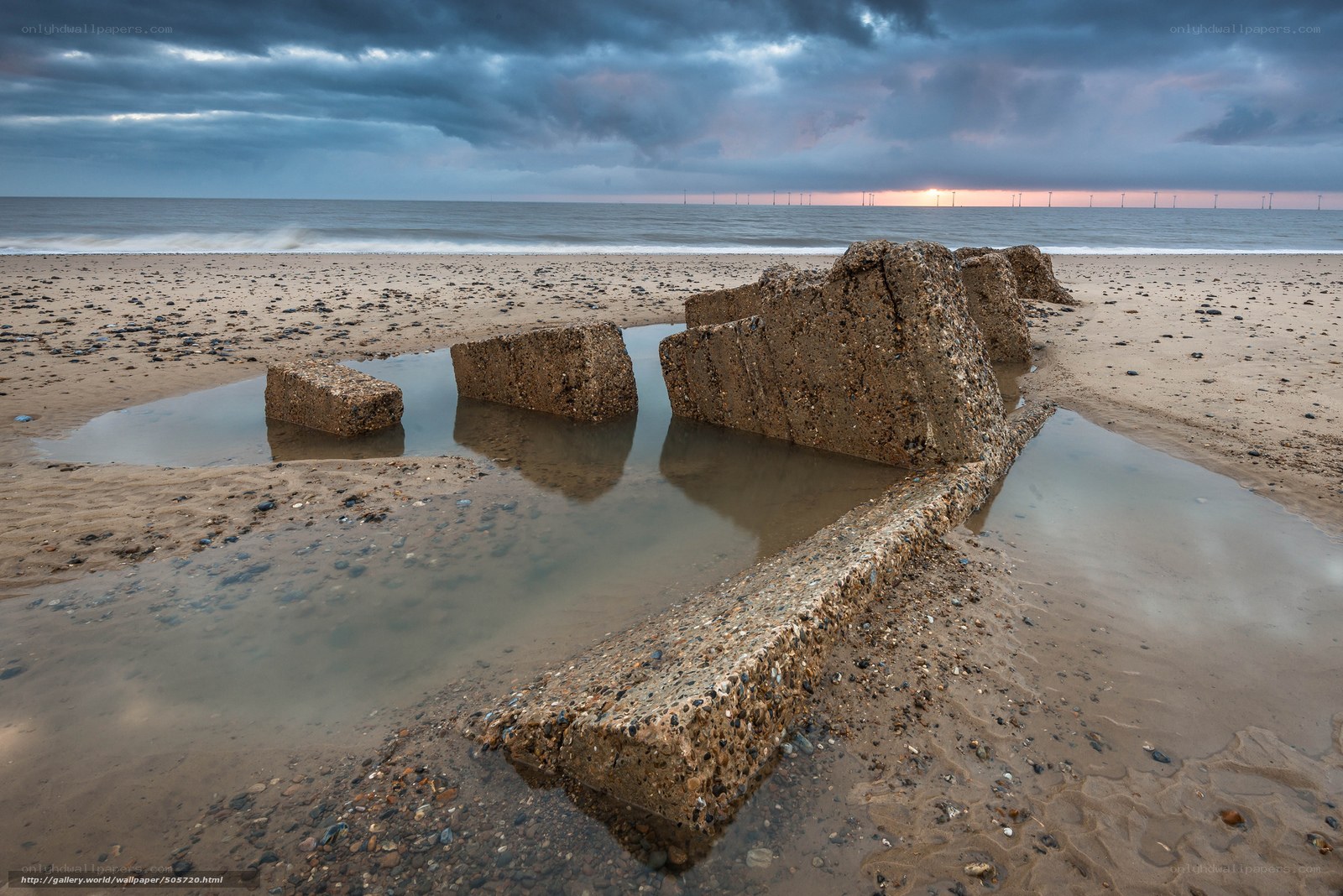 Concrete blocks on beach at sunset