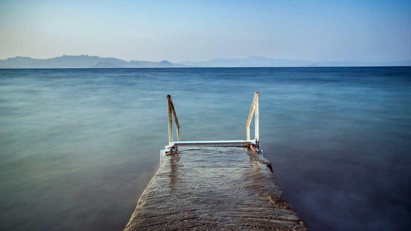 Concrete Pier Extending into Sea — Blue, Serene, Afternoon, Photograph