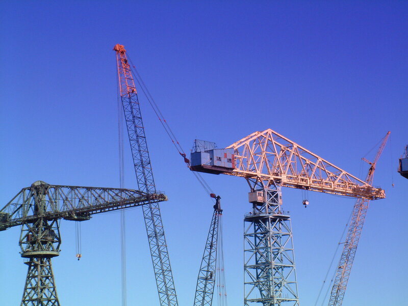 Construction cranes against blue sky