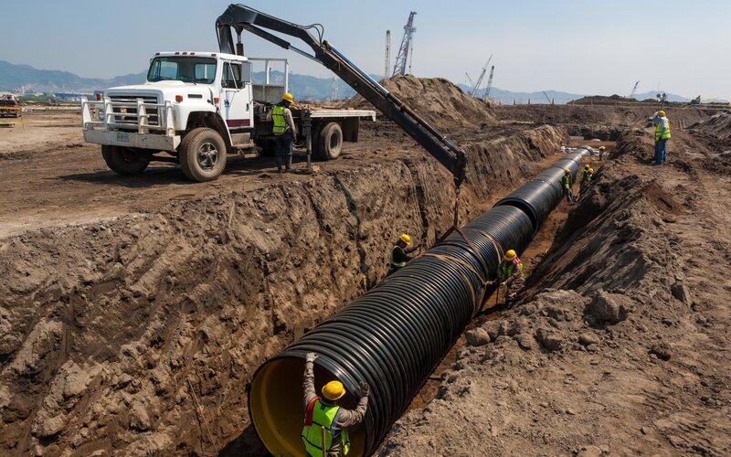 Construction workers installing pipe