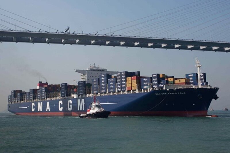 Container ship passing under bridge