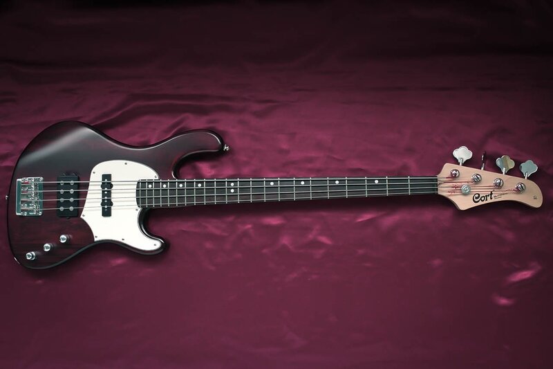 Cort bass guitar on purple fabric