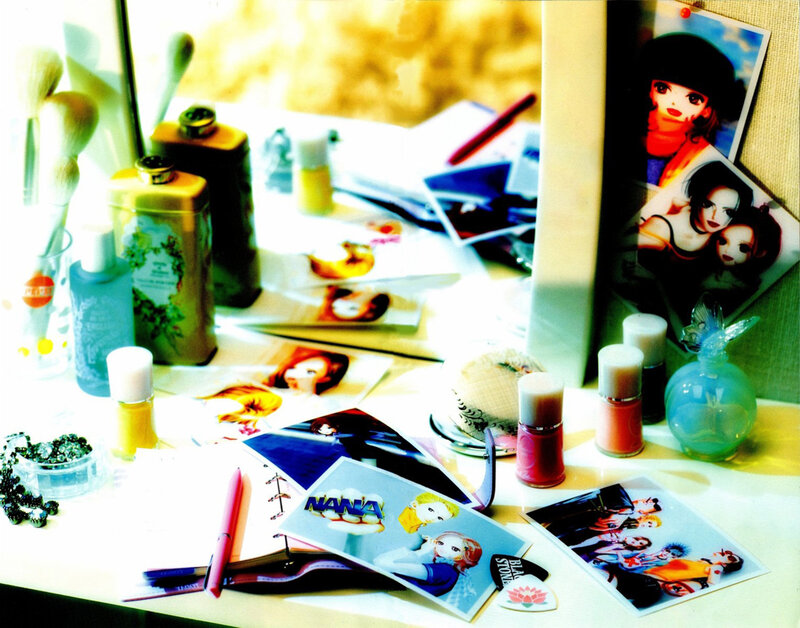 Cosmetics and anime photos on a desk
