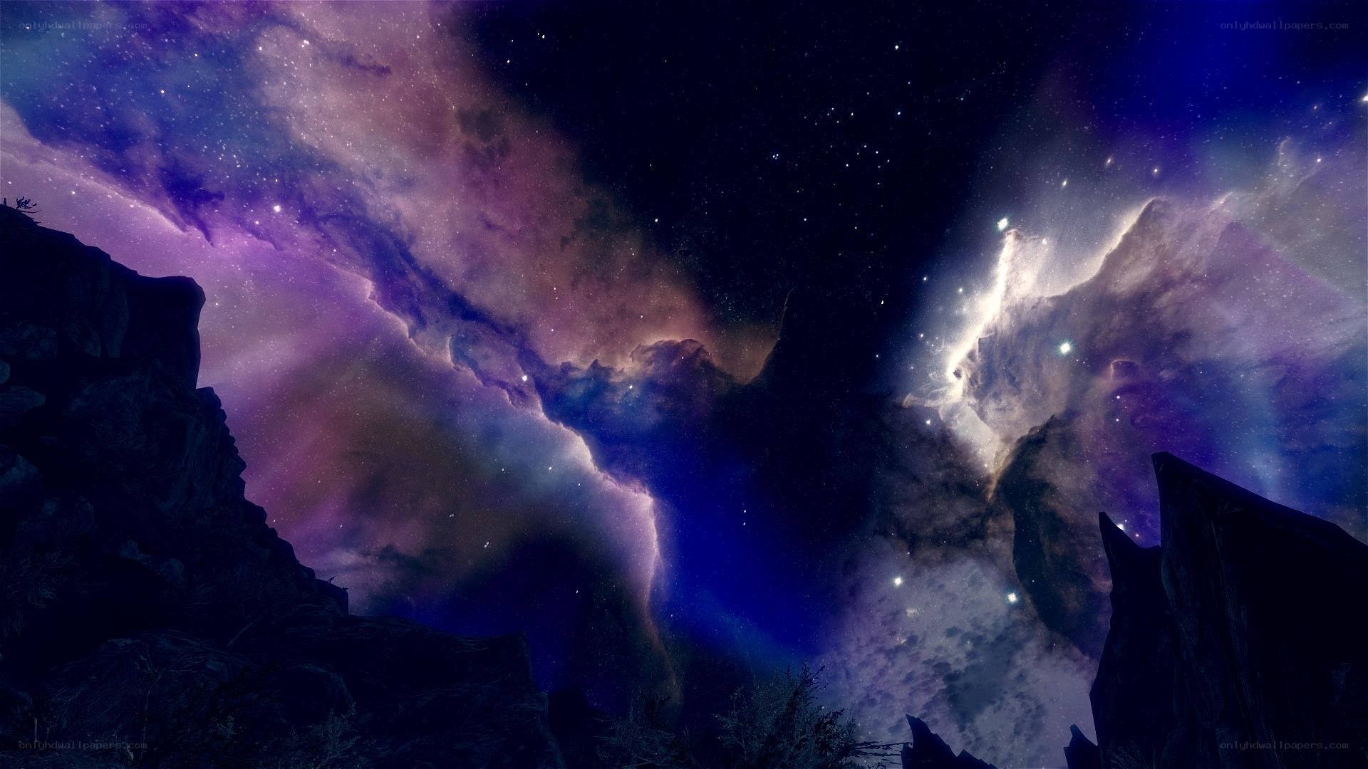 Cosmic nebula over rocky landscape