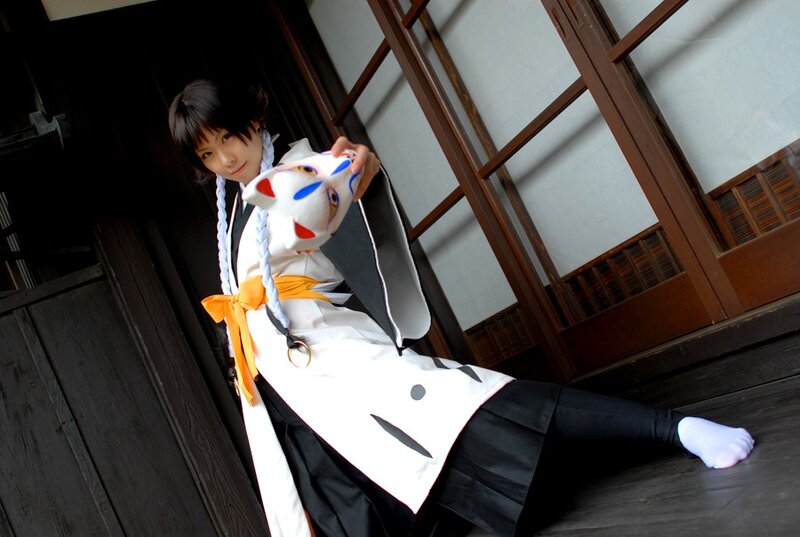 cosplayer holding a fox mask
