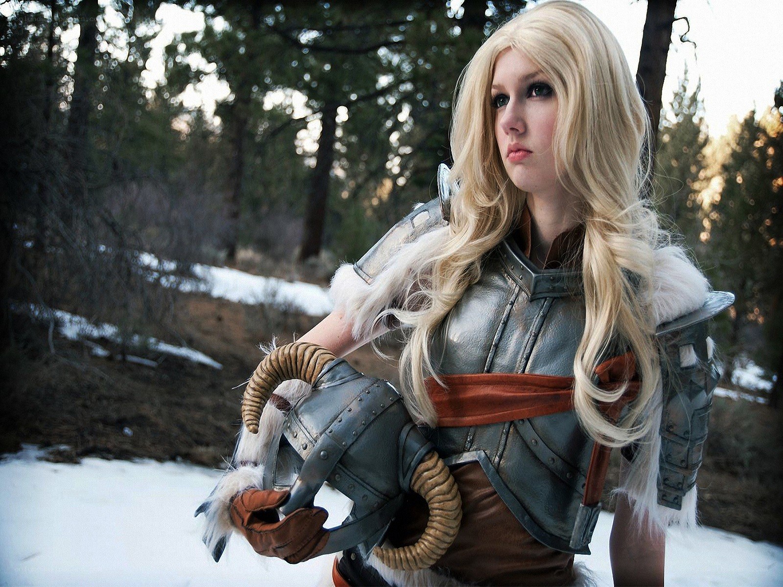 cosplayer in armor holding helmet