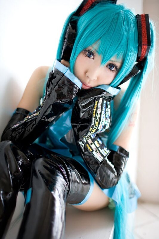 cosplayer in blue wig and black outfit