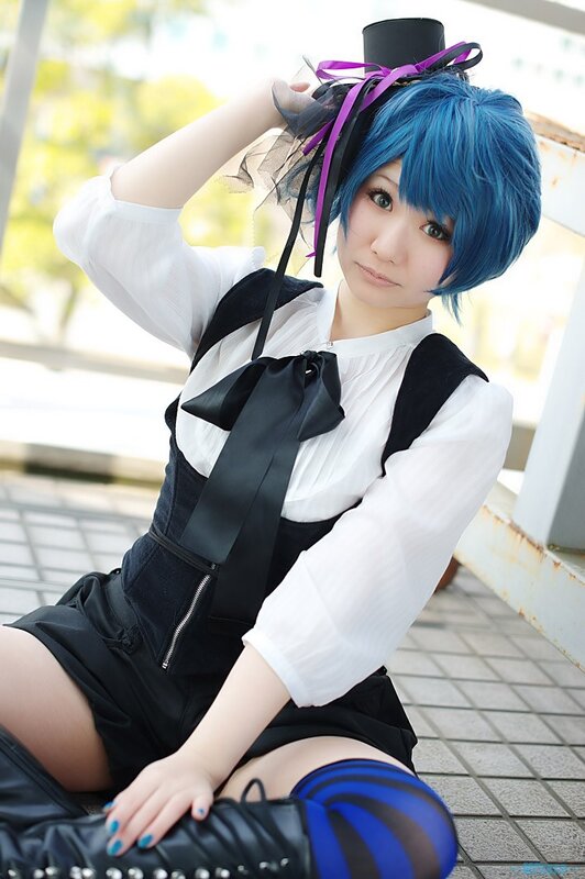 cosplayer in blue wig and black outfit